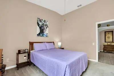 a bedroom with a bed with a purple blanket at Windsor Palms Villa with Very Private Pool in Kissimmee