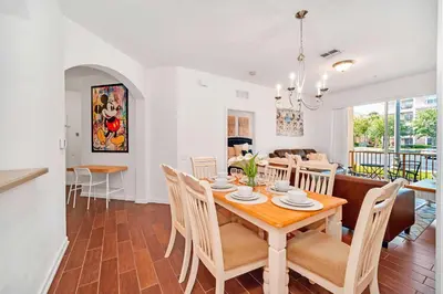 a dining room and living room with a table and chairs at Cozy 3BR Apartment - Vista Cay Resort near Disney! in Orlando