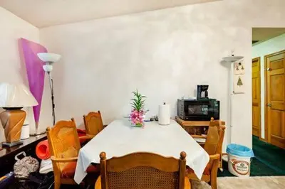 a dining room with a table and chairs and a television at Red Brick House in Kissimmee
