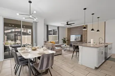 a kitchen and living room with a table and chairs at Stunning home at Storey Lake close to Disney in Kissimmee