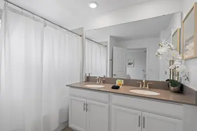 a bathroom with two sinks and a large mirror at Stunning home at Storey Lake close to Disney in Kissimmee