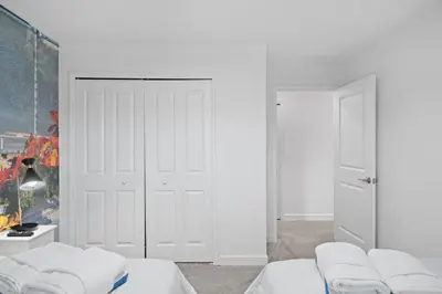 a white room with two beds and a closet at Stunning home at Storey Lake close to Disney in Kissimmee