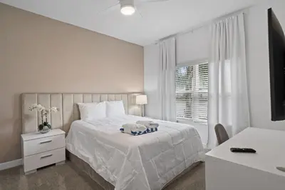 a bedroom with a white bed and a window at Stunning home at Storey Lake close to Disney in Kissimmee