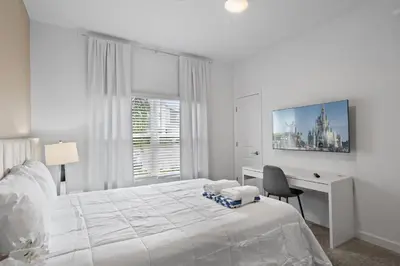 a white bedroom with a desk and a bed at Stunning home at Storey Lake close to Disney in Kissimmee