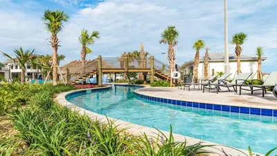a pool at a resort with palm trees at Magic Moments in Kissimmee