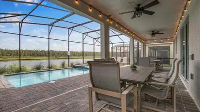 a patio with a table and chairs and a pool at Sierra Sky in Kissimmee