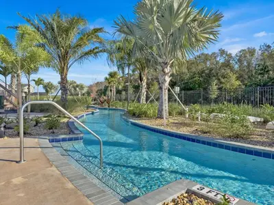 a swimming pool with palm trees in a resort at Sierra Sky in Kissimmee
