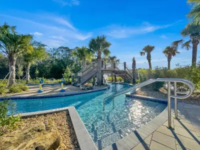 a swimming pool with palm trees and a slide at Sierra Sky in Kissimmee