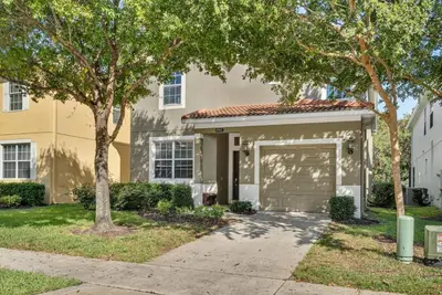 a house with a garage and a tree at 5BD - Movie Room, Pool, BBQ - Near Disney World in Kissimmee