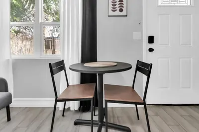 a table and two chairs in a room with a door at Modern Cuartito near Winter Park in Orlando