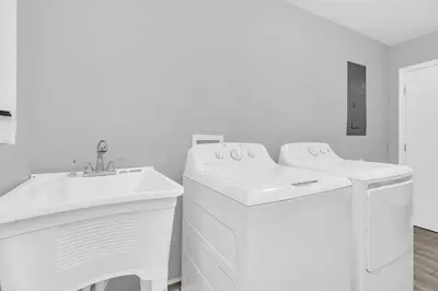 a white bathroom with a sink and a washing machine at Modern Cuartito near Winter Park in Orlando