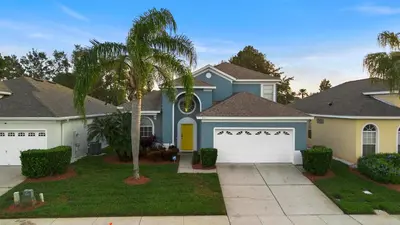 a house with a palm tree in front of it at Lux 6BrVilla -Pool&ResortAmenities -10mins to Parks in Kissimmee