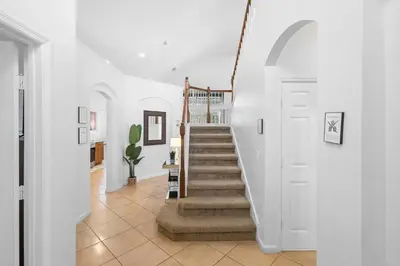 a staircase in a home with white walls at Lux 6BrVilla -Pool&ResortAmenities -10mins to Parks in Kissimmee