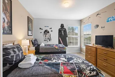 a bedroom with two beds and a flat screen tv at Lux 6BrVilla -Pool&ResortAmenities -10mins to Parks in Kissimmee