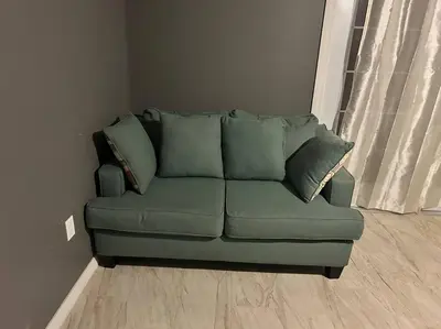 a green couch with pillows in a living room at Tranquile Vacation Home near Universal studio in Orlando