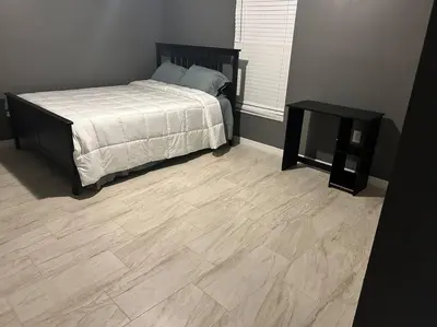 a bedroom with a bed and a wooden floor at Tranquile Vacation Home near Universal studio in Orlando