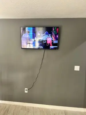 a flat screen tv hanging on a wall at Tranquile Vacation Home near Universal studio in Orlando