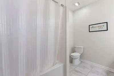 a white bathroom with a shower curtain and a toilet at Storey Lake Resort 2bd Condo Overlooking Water #840 condo in Kissimmee