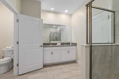 a bathroom with a toilet and a sink and a shower at 9 min to Disney w Pool ARCADE FREE Waterpark Villa in Kissimmee