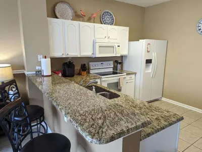 a kitchen with white appliances and a granite counter top at La Dolce Vita Gated resort in Orlando