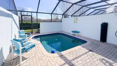 a swimming pool with two blue chairs and a chair istg at Tequilla Sunrise at Windsor Hills in Orlando