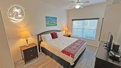 a bedroom with a bed and a desk and a window at Villas Standard Seven Dwrafs Resort - Close to Disney in Kissimmee