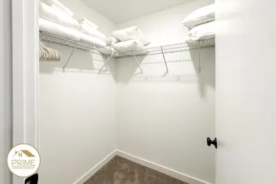 a walk in closet with white walls and shelves at New 3BD3BA Townhouse Themed Near Disney in Kissimmee