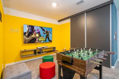 a room with a foosball table and a tv at 3221 Brand New Family 3BD Townhouse near Disney in Kissimmee