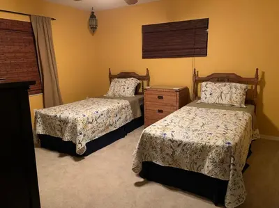 a bedroom with two beds and a dresser at Lakefront Home Where You Can Retreat and Relax in Orlando