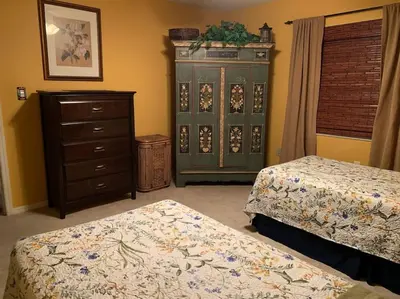 a bedroom with two beds and a dresser at Lakefront Home Where You Can Retreat and Relax in Orlando