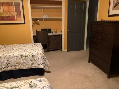 a bedroom with a bed and a dresser and a desk at Lakefront Home Where You Can Retreat and Relax in Orlando