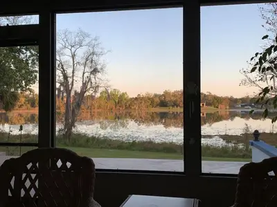 a view of a lake seen through a window at Lakefront Home Where You Can Retreat and Relax in Orlando