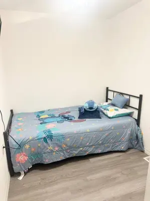 a bed with a comforter on it in a bedroom at The Pink House of Celebration in Kissimmee