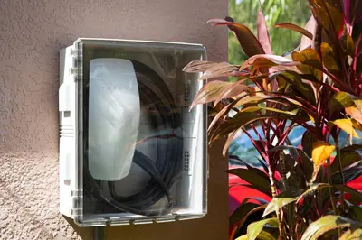 an electronic device sitting on a wall next to a plant at Family 4br House w Pool near to Disney Much More in Kissimmee