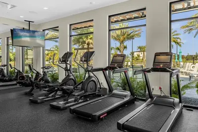 a gym with treadmills and elliptical machines at 5 Bedroom 5 Bathroom Paradiso Grande 10352 in Orlando