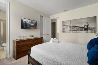a bedroom with a large bed and a bathroom at Private Heated Pool Billiard lounge 6MI to Disney in Orlando