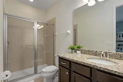 a bathroom with a shower and a toilet and a sink at Private Heated Pool Billiard lounge 6MI to Disney in Orlando