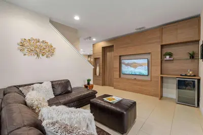 a living room with a couch and a tv at Private Heated Pool Billiard lounge 6MI to Disney in Orlando