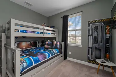 a bedroom with a white bunk bed and a tv at Private Heated Pool Billiard lounge 6MI to Disney in Orlando