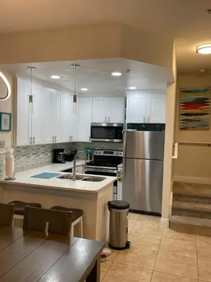 a kitchen with white cabinets and a stainless steel refrigerator at Venetian Bay Villages in Kissimmee