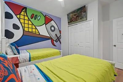 a bedroom with two beds and a painting on the wall at Amazing House Amazing Amenities in Orlando