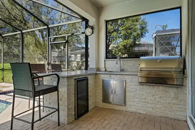 a outdoor kitchen with a sink and a stove at Amazing House Amazing Amenities in Orlando