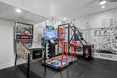 a room with several video game machines and a mural at Amazing House Amazing Amenities in Orlando
