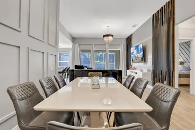 a dining room with a white table and leather chairs at Free Water Park Luxury Living in Orlando