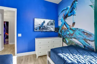 a bedroom with a blue wall with a painting of a mermaid at Free Water Park Luxury Living in Orlando