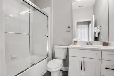 a white bathroom with a toilet and a shower at Free Water Park Luxury Living in Orlando