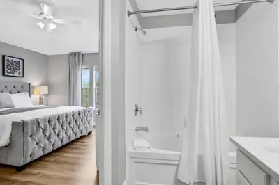 a white bedroom with a bed and a bath tub at Windsor Hills Water Park Adventure Home in Orlando