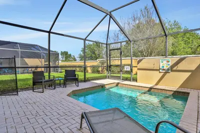 a swimming pool with two chairs and a glass house at Windsor Hills Water Park Adventure Home in Orlando