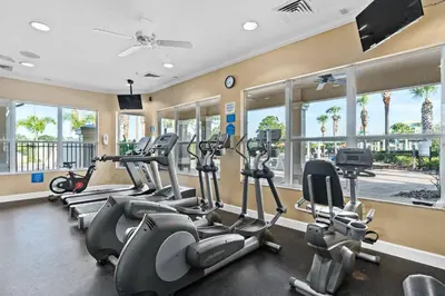 a gym with several treadmills and elliptical machines at Elegant Townhome w Water Park near Disney Parks in Orlando