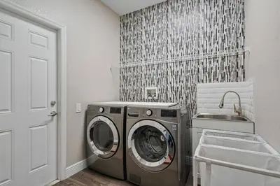 a laundry room with a washing machine and a sink at 6BR Fun in the Sun with FREE water park in Orlando